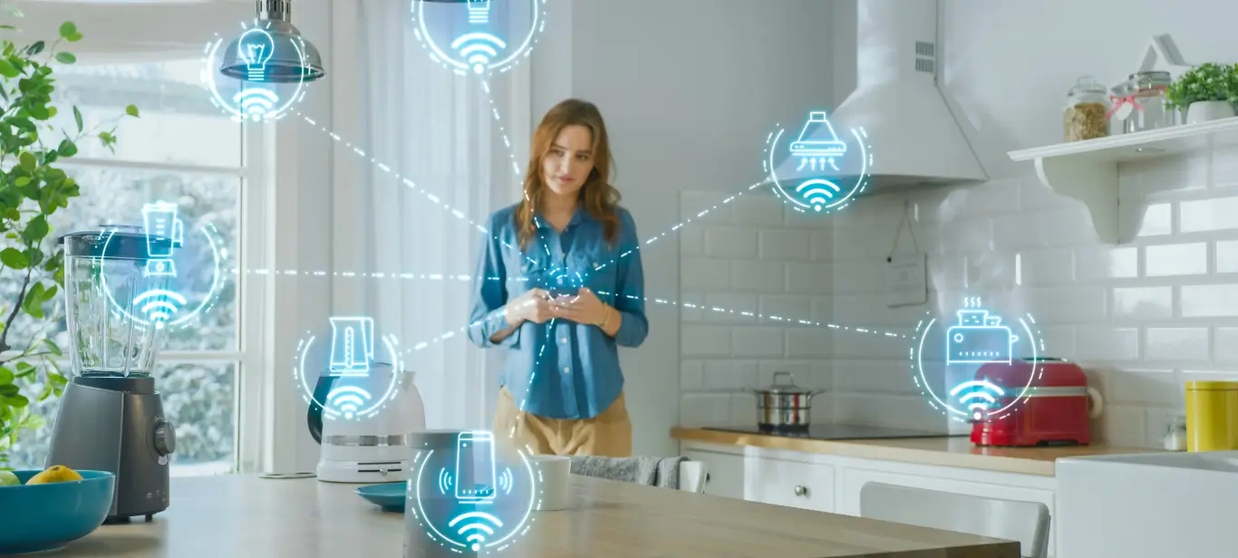 A woman stands in a kitchen with smart home technology.