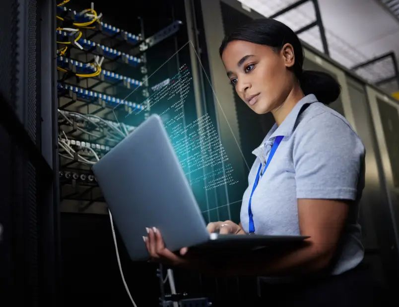 Female software engineer examining laptop